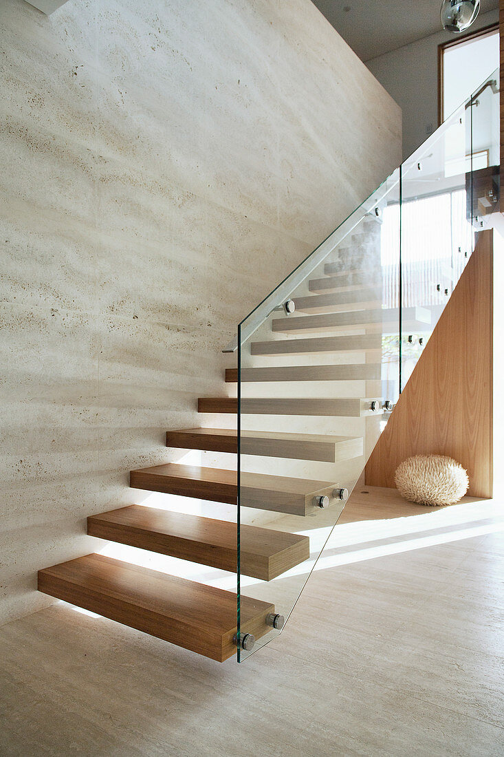 Wooden stairs with glass railings in an ecological architect's house