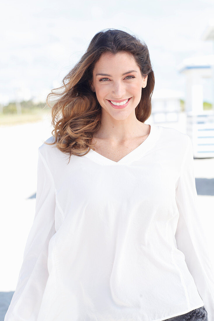 A young woman wearing a white long-sleeved blouse