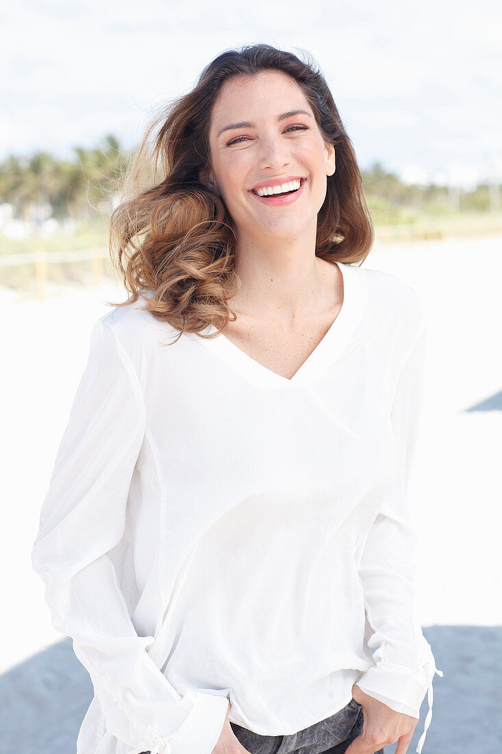 A young woman wearing a white long-sleeved blouse