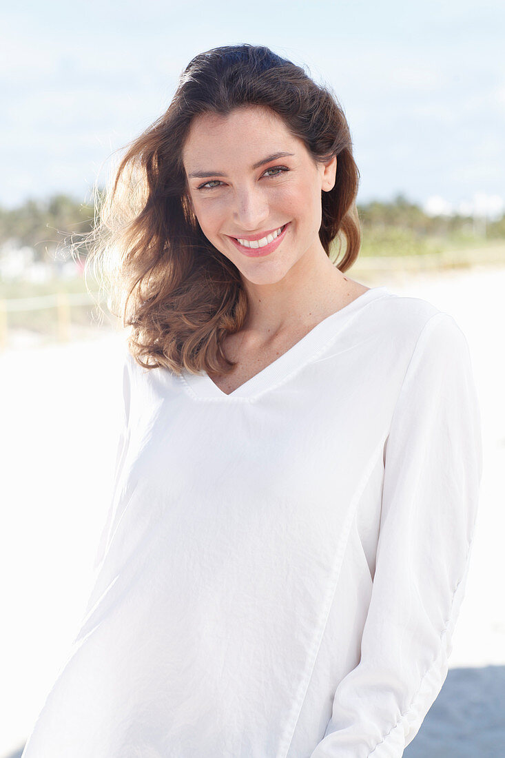 A young woman wearing a white long-sleeved blouse