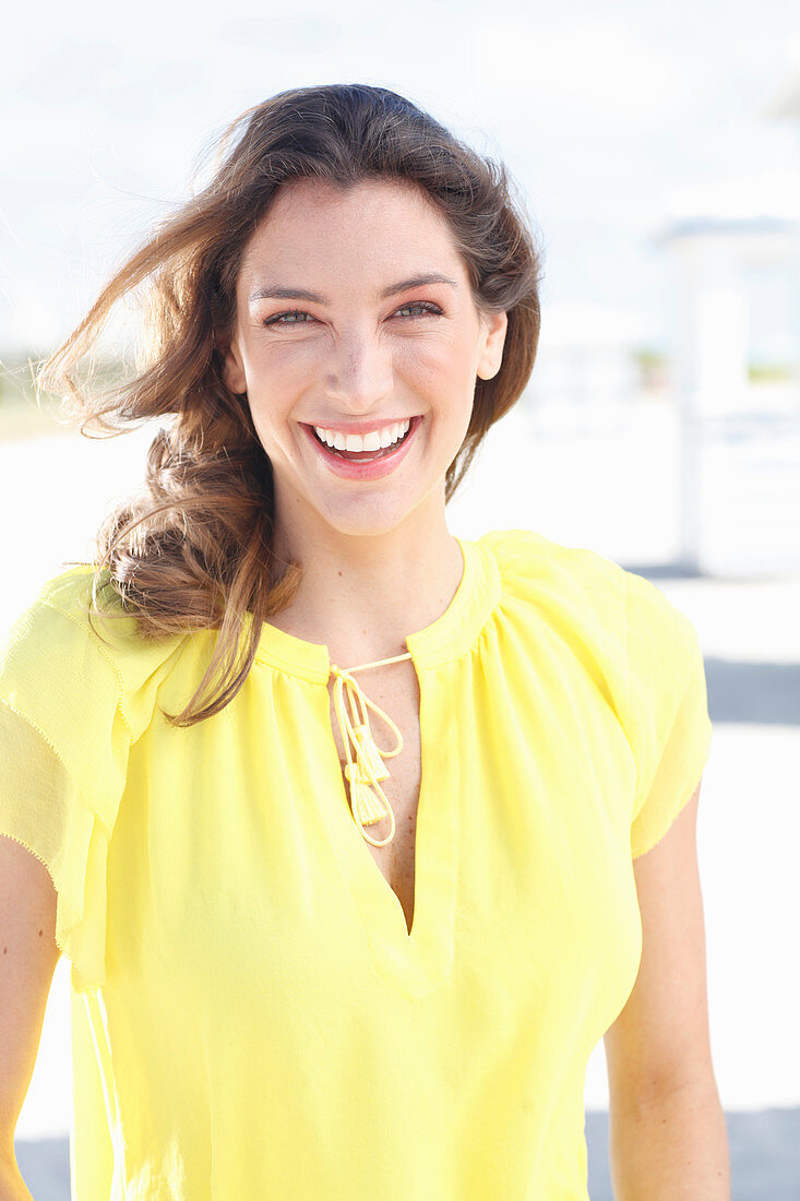 A young woman wearing a yellow sleeveless top