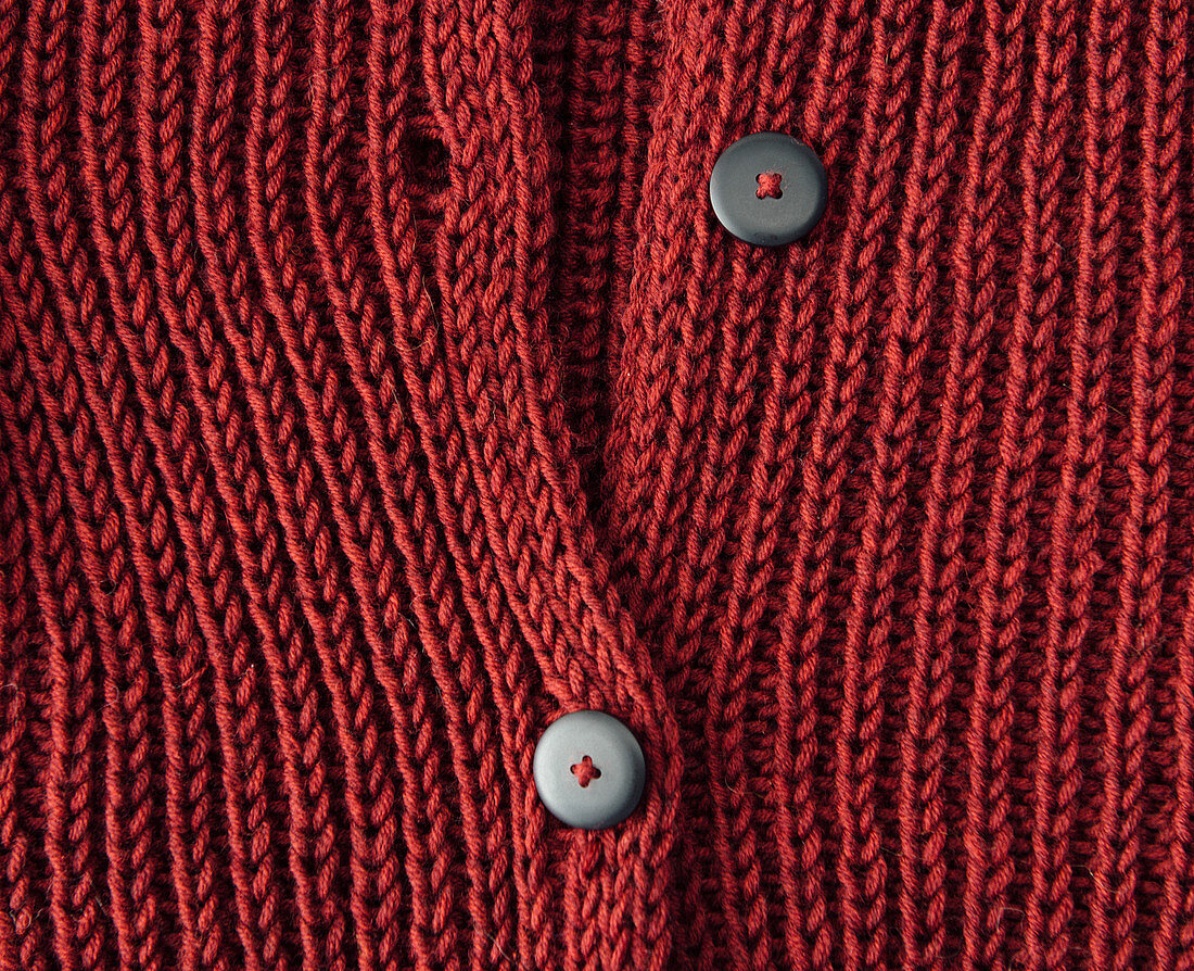 A red, hand-knitted cardigan with a button placket
