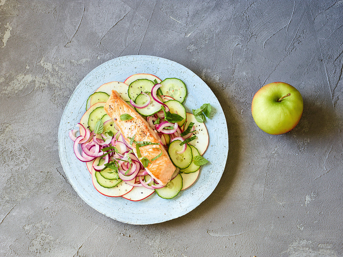 Salmon on a bed of cucumber and apples