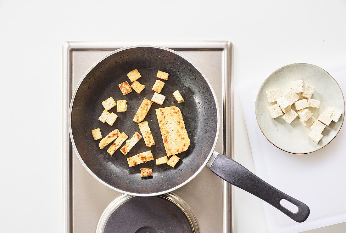 Thinly sliced tofu being fried