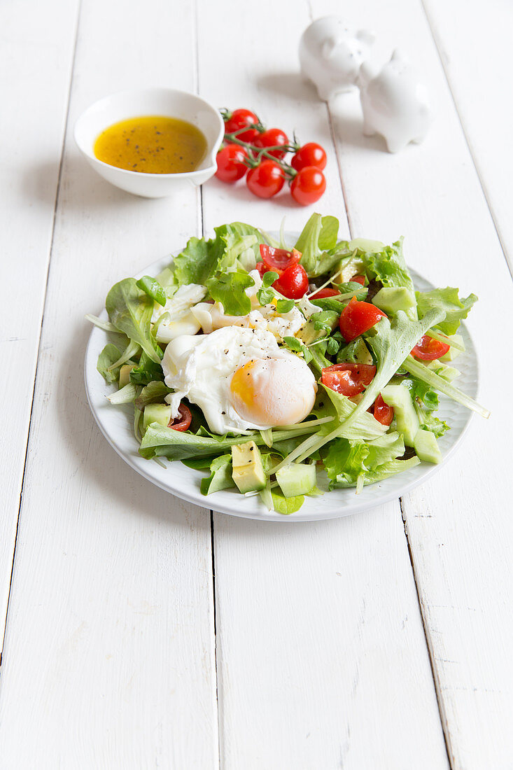 Blattsalat mit pochierten Eiern und Kirschtomaten