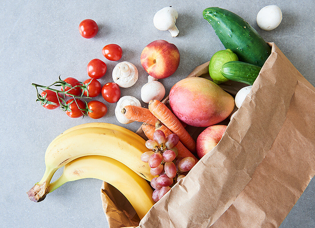 Weekly shopping: fresh fruit and vegetables in a paper bag