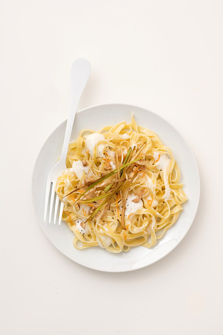 Tagliatelle mit Lauch-Käse-Sauce, knusprigen Lauchstreifen und Orangenabrieb