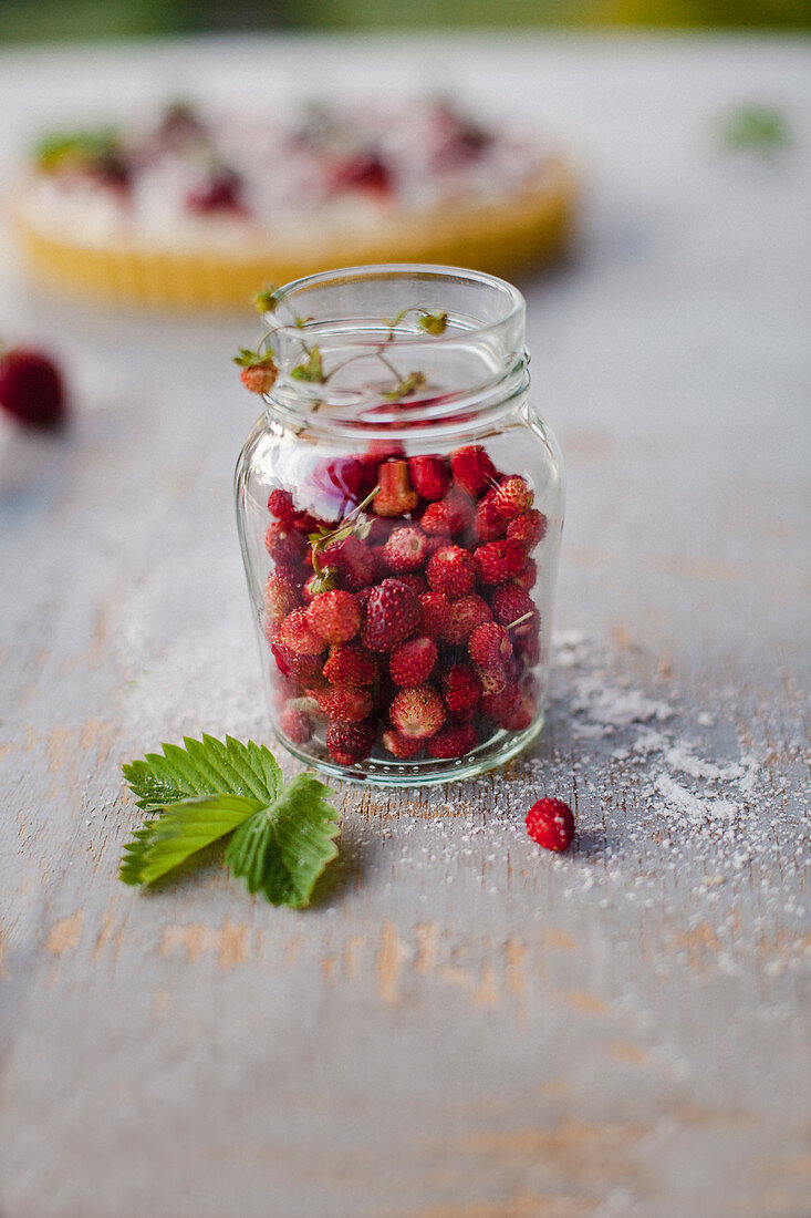 Fresh wild strawberries in a glass jar