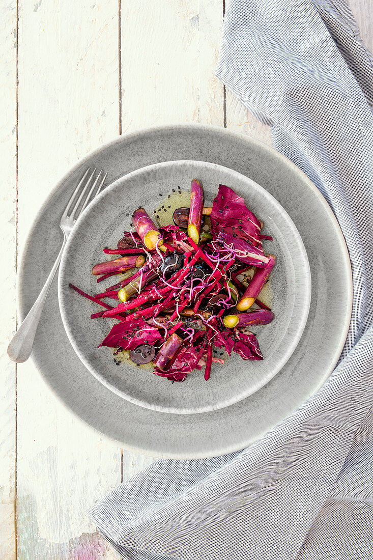 A salad with purple asparagus, beetroot, grapes and radicchio