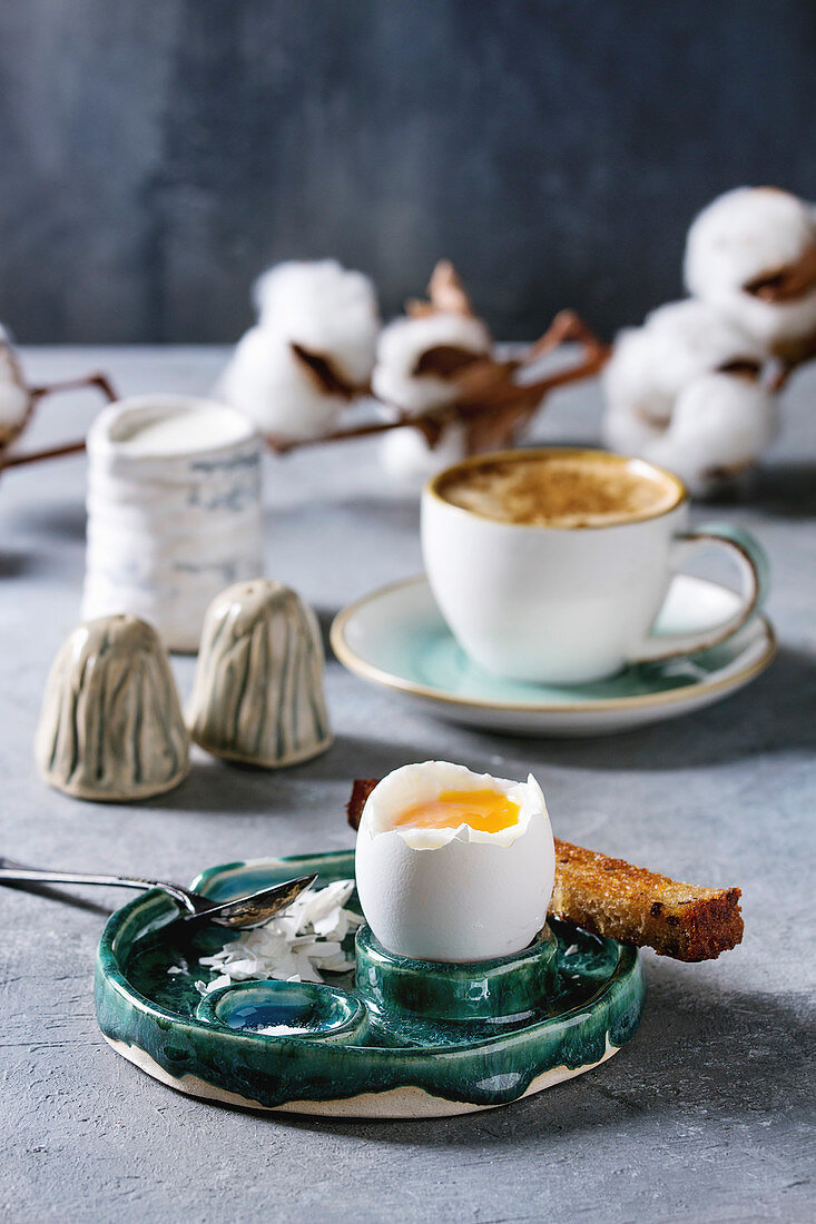 Frühstück mit weichgekochtem Ei, Brotsticks und Tasse Kaffee