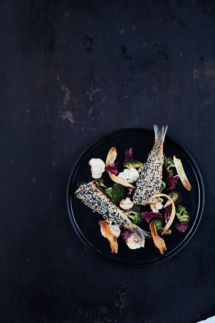 Herring coated in sesame with a vegetable garnish