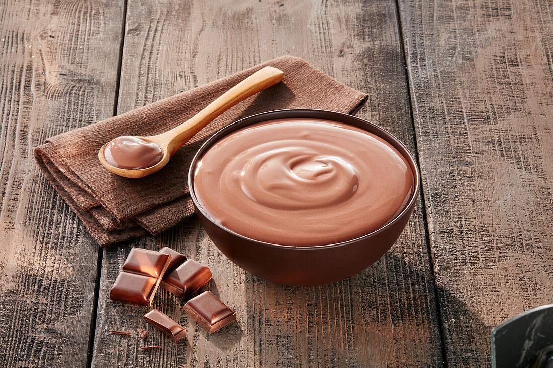 Schokoladenpudding in Schale und auf Löffel