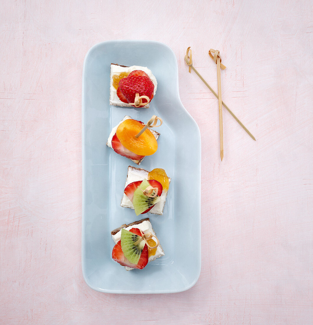 Fruity bread skewers with creamy quark on crackers
