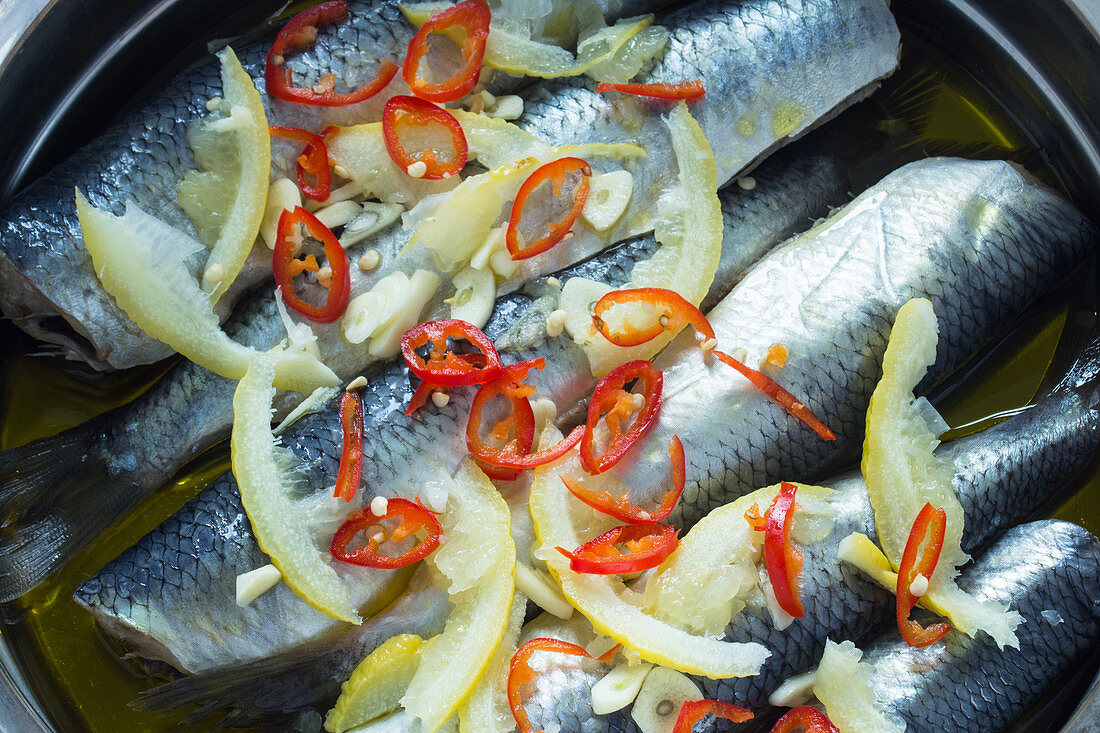 Young herring in a lemon and garlic marinade in a roasting tin