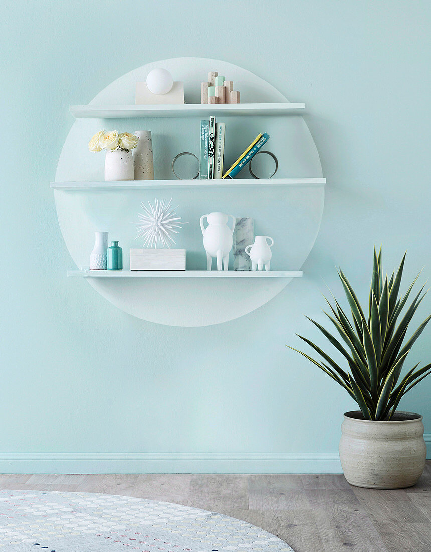 Shelf boards with decorative objects on a round panel