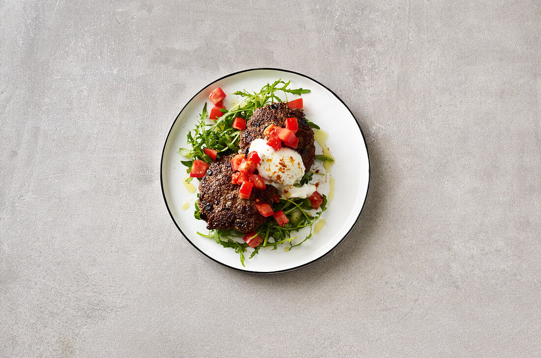 Oriental meatballs on a tomato and rocket salad