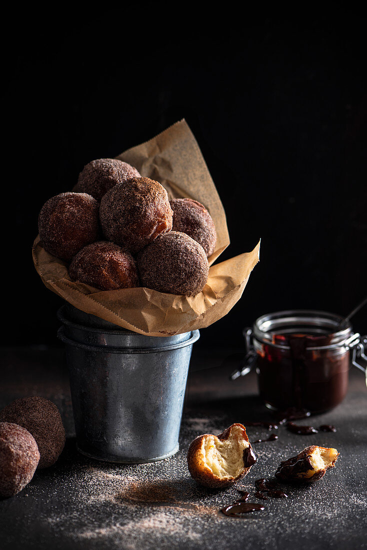 Homemade mini doghnuts coated in cinnamon and sugar with dipping chocolate sauce