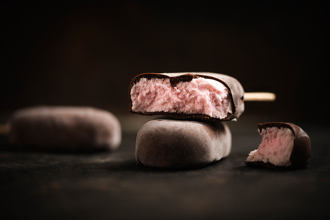 Vegan strawberry popsicles covered with dark chocolate