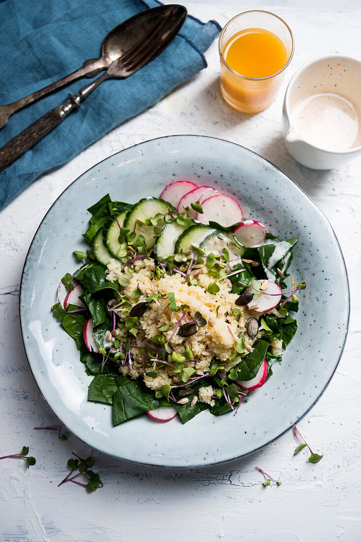 Bulgur-Spinat-Salat mit Radieschen, Gurke, Kürbis-und Sonnenblumenkernen, Kresse und veganem Joghurt-Dressing