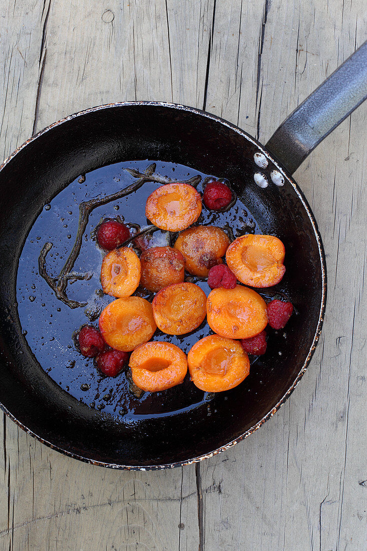 Gebratene Aprikosen und Himbeeren in Pfanne