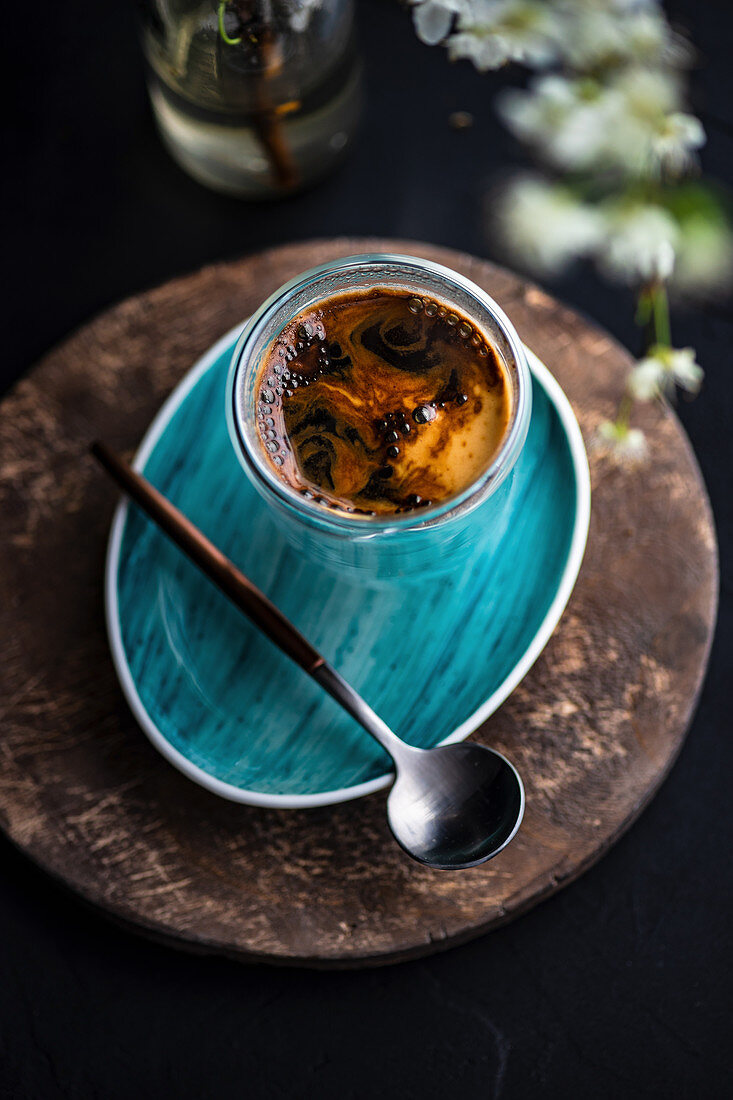 Blooming cherry tree branch and glass of coffee