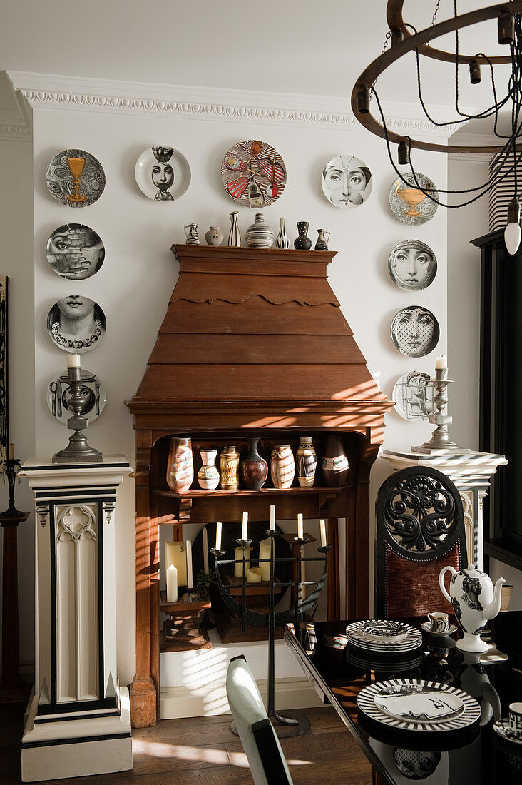 Wooden mantelpiece decorated with pillars and eclectic collection of vases and plates