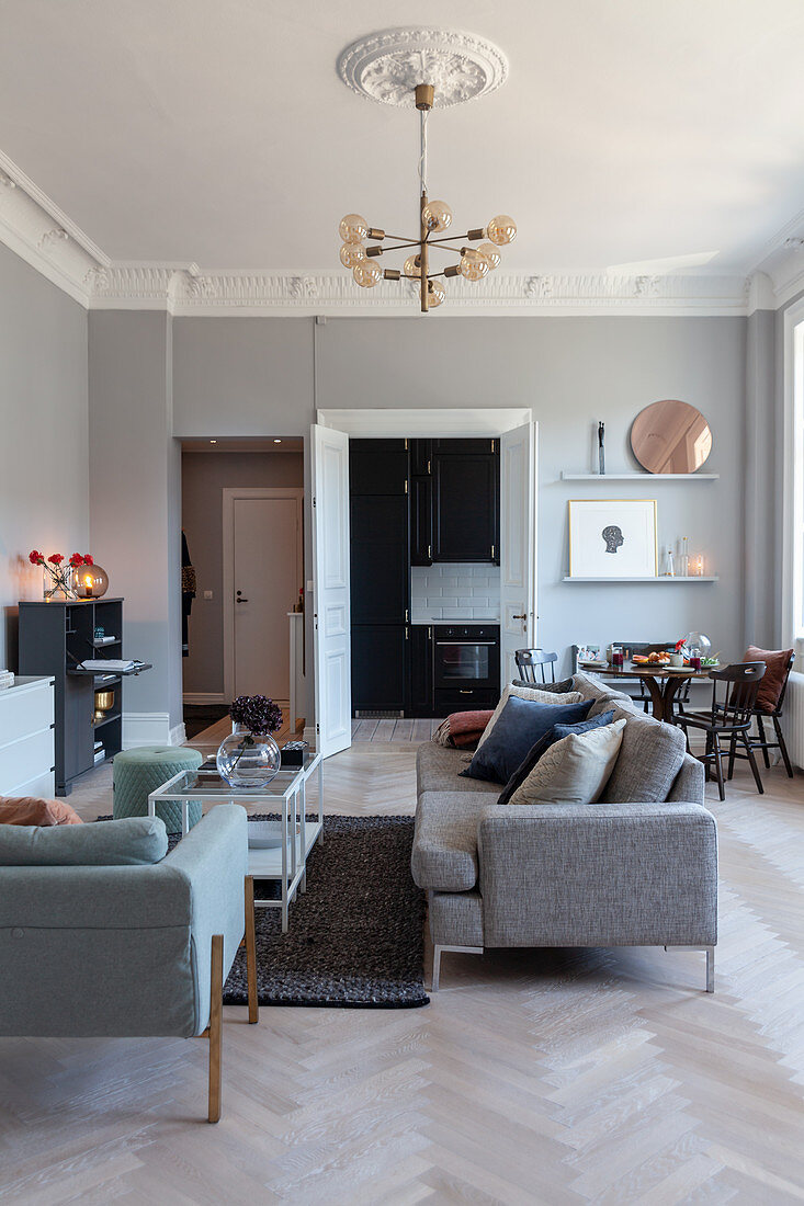 Pale grey walls and stucco friezes in living room of renovated period apartment