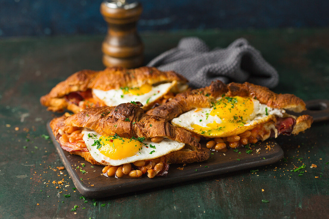 Croissants, baked with cheese, beans and fried eggs, sprinkled with parsley