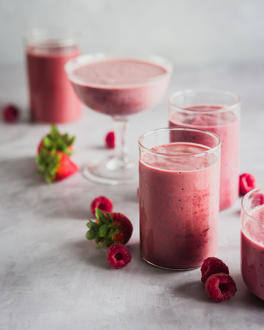 Himbeer-Erdbeer-Smoothies in verschiedenen Gläsern