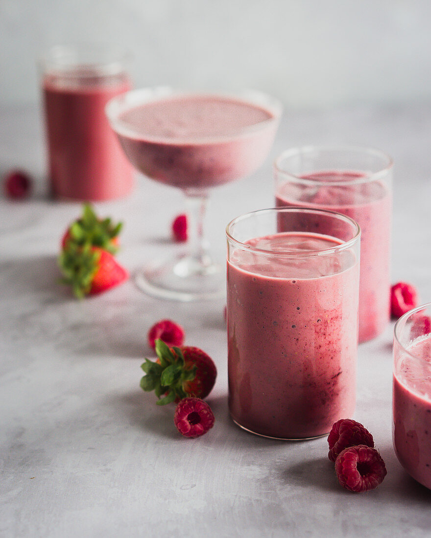 Raspberry and strawberry smoothies in different glasses