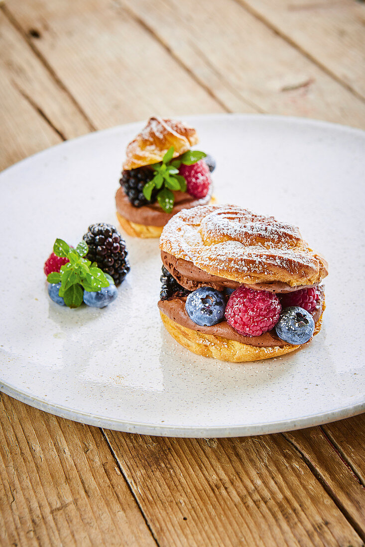 A choux pastry doughnut with chocolate cream and berries