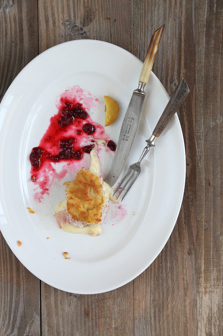 Remains of cordon bleu with fried potatoes and cranberries