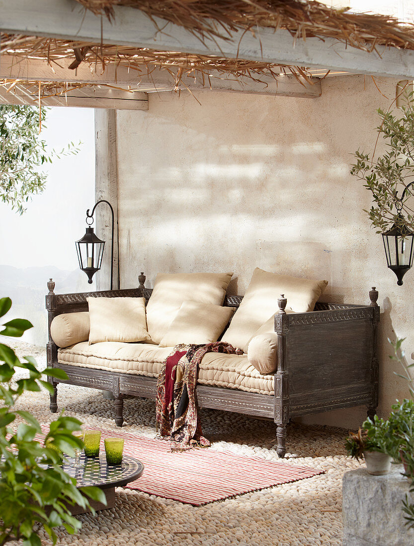 Couch on roofed terrace with mosaic pebble floor