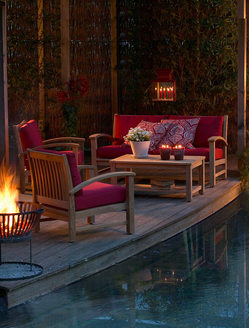Loungemöbel auf der Terrasse am Pool am Abend bei Kerzenlicht