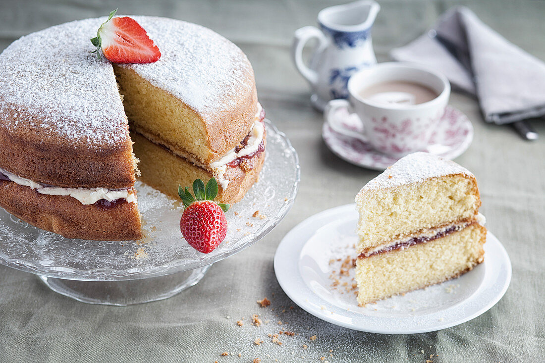 Traditional Victoria sponge with a slice removed and on a plate