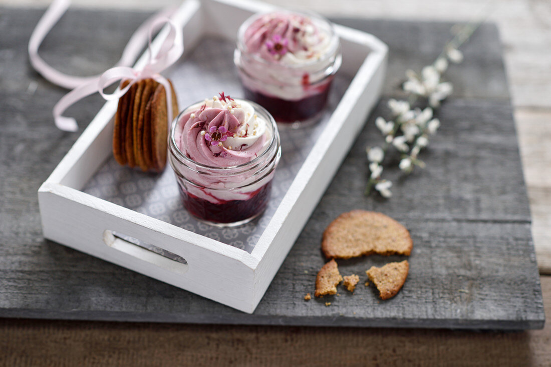 Vegan dessert in glasses with wild berry compote, cream cheese and caramel biscuits