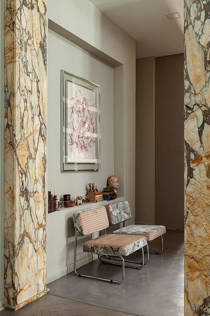 Designer chairs in corridor with marble pillars