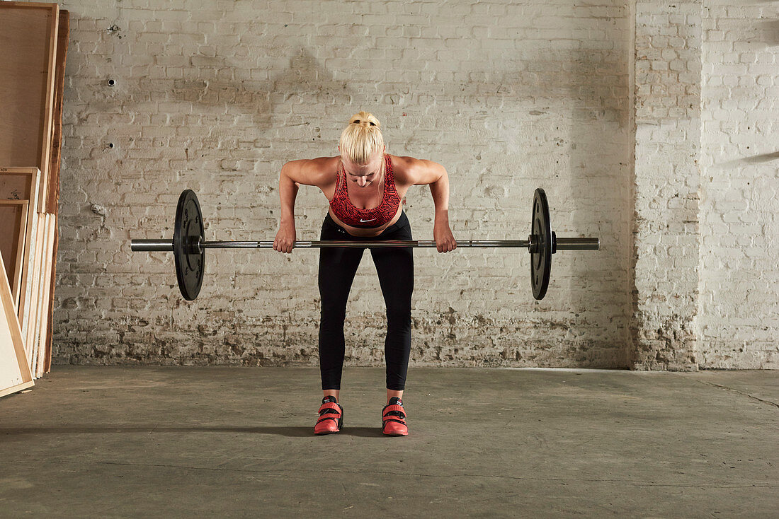 A young woman lifting a barbell