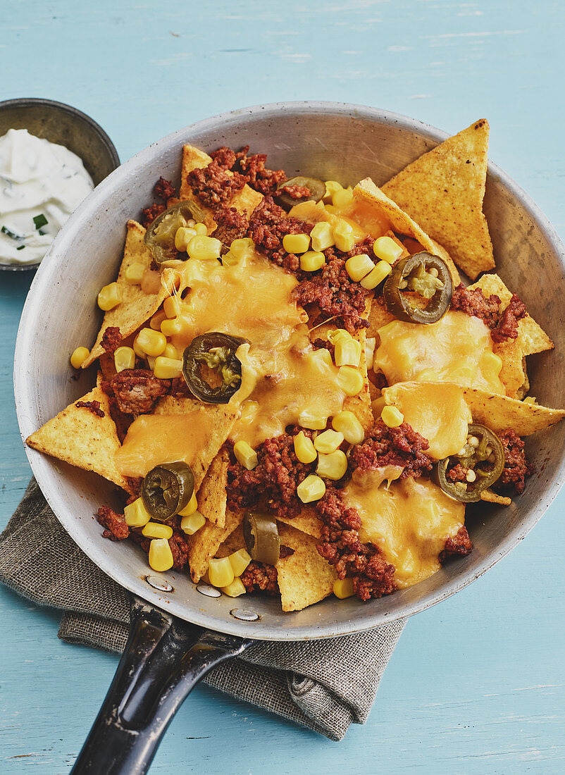 Nachos with minced meat, jalapenos and sweetcorn in a pan