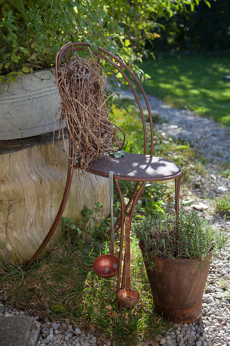 Old chair painted rust-red decorating garden