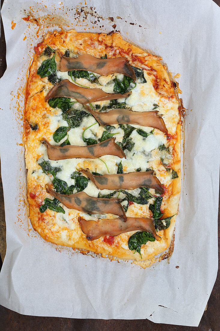 Pizza mit Mozzarella, Spinat und Rohschinken