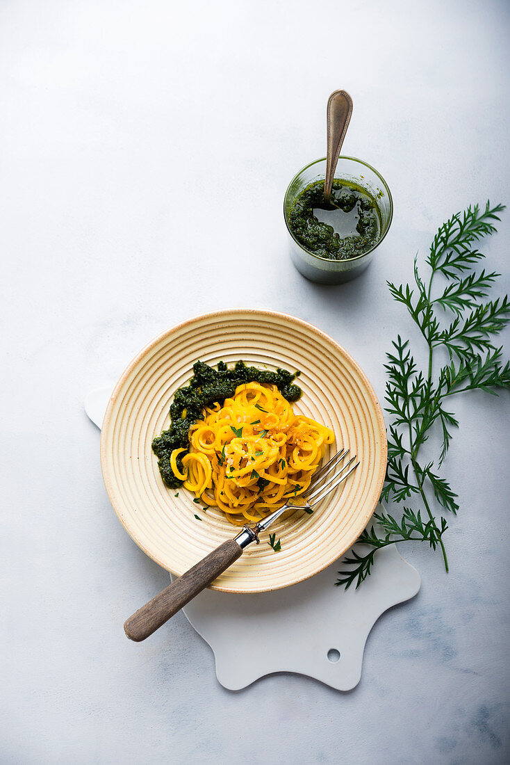 Yellow carrot spirals with vegan pesto made form carrot leaves