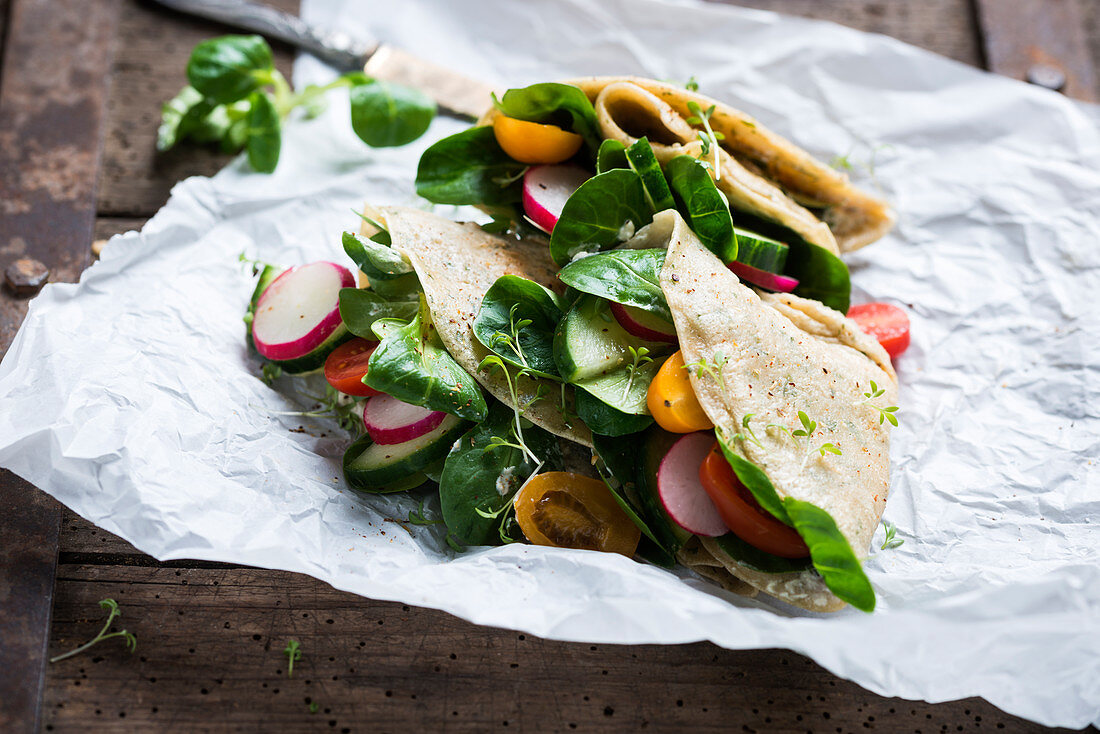 Vegan herb pancakes with almond cream cheese substitute and colourful vegetables