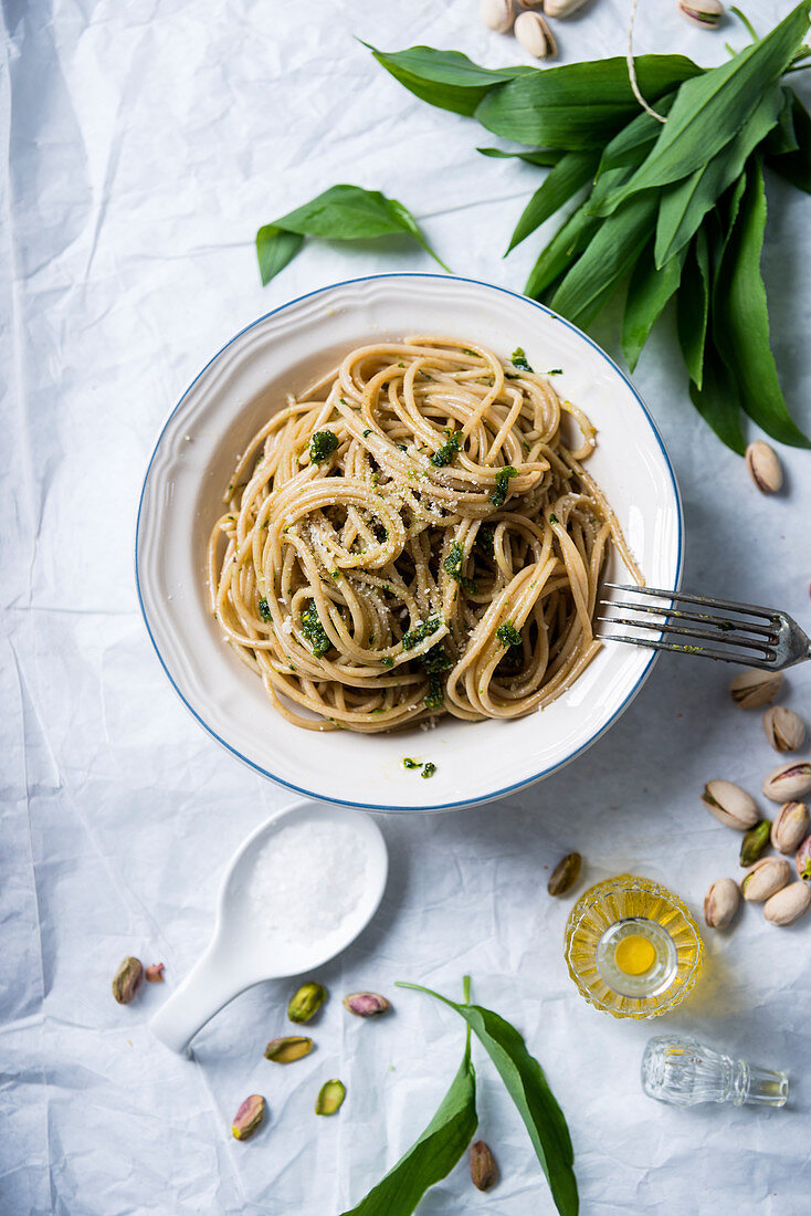 Wholemeal spaghetti with wild garlic and pistachio nut pesto and almond cheese substitute (vegan)