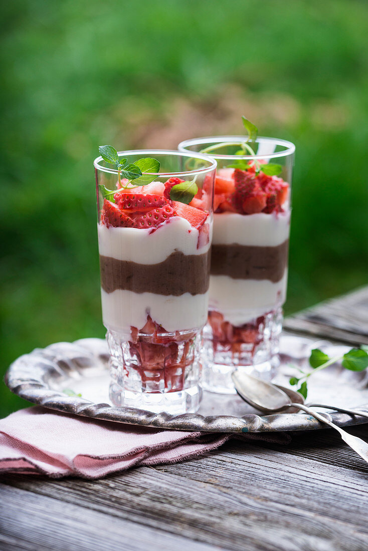 Veganes Dessert im Glas aus zweierlei Sojajoghurt und frischen Erdbeeren