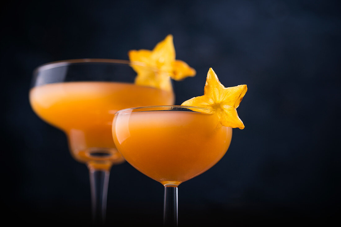 Peach Velvet Cocktail ( Sekt, Orangensaft, Pfirsichlikör und Grenadine), dekoriert mit Karambole