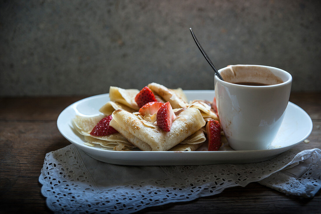 Vegan crepes with strawberries, chocolate sauce and roasted almonds
