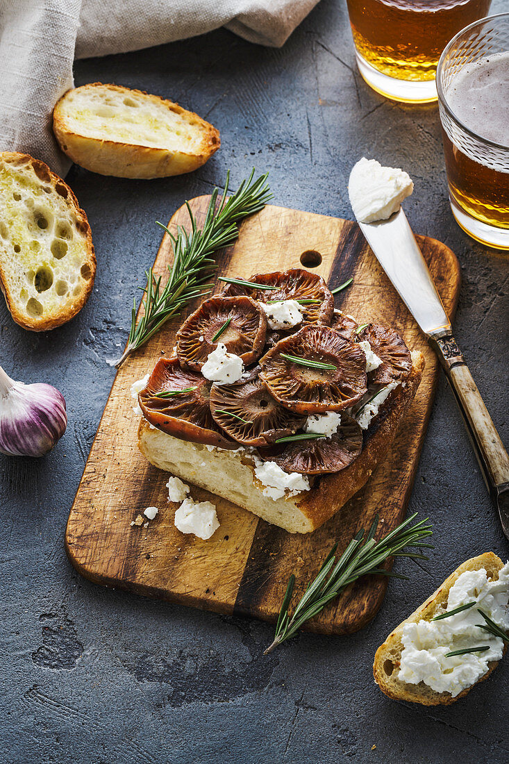 Bruschetta with saffron milk caps mushrooms, soft cheese and rosemary