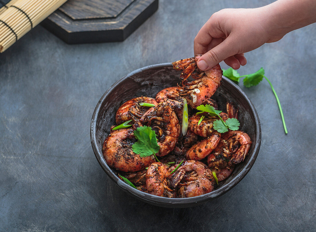 Delicious shrimp in black pepper sauce in hand