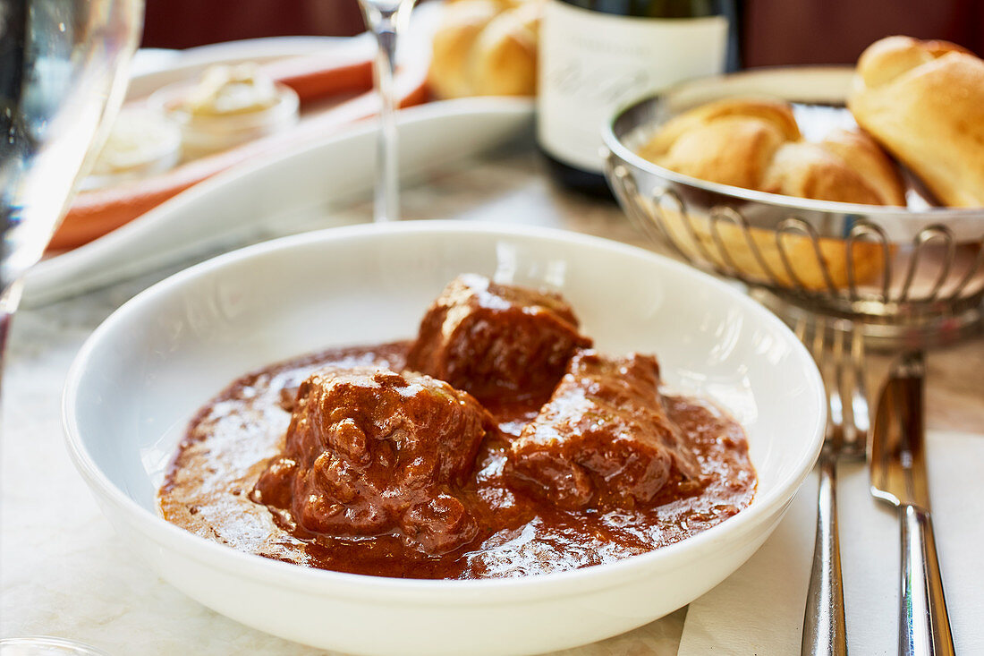 Goulash and sausage with bread on a table in a restaurant